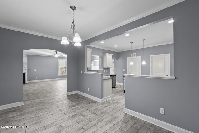 kitchen with pendant lighting, white cabinets, ceiling fan, crown molding, and light hardwood / wood-style flooring