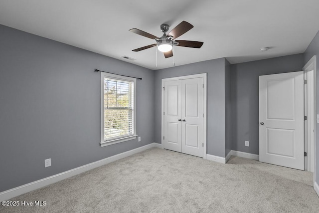 unfurnished bedroom featuring ceiling fan, a closet, and light carpet