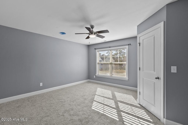 spare room with ceiling fan and light carpet