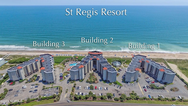 drone / aerial view featuring a beach view and a water view