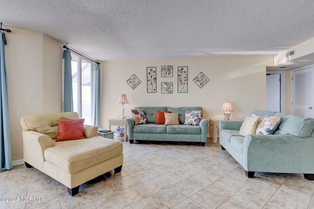 tiled living room featuring a textured ceiling