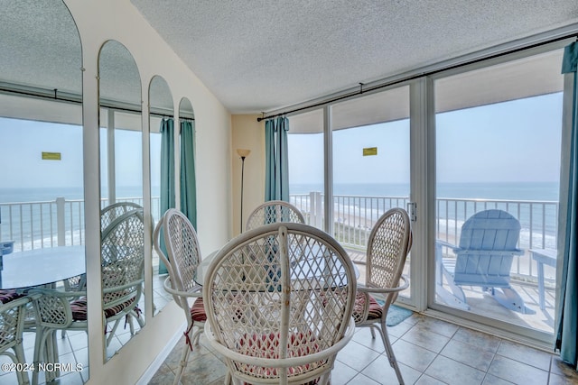 sunroom / solarium featuring plenty of natural light and a water view