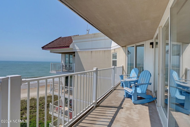 balcony featuring a beach view and a water view