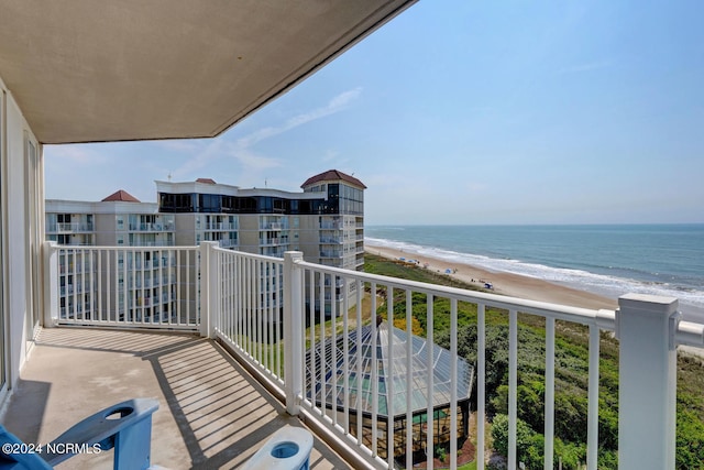 balcony featuring a view of the beach and a water view