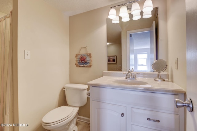 bathroom with tile patterned flooring, vanity, toilet, and a textured ceiling