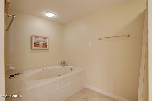 bathroom featuring a textured ceiling, tiled bath, and tile patterned floors