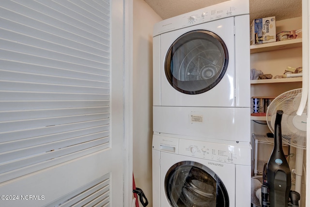 laundry area featuring a textured ceiling and stacked washer / dryer