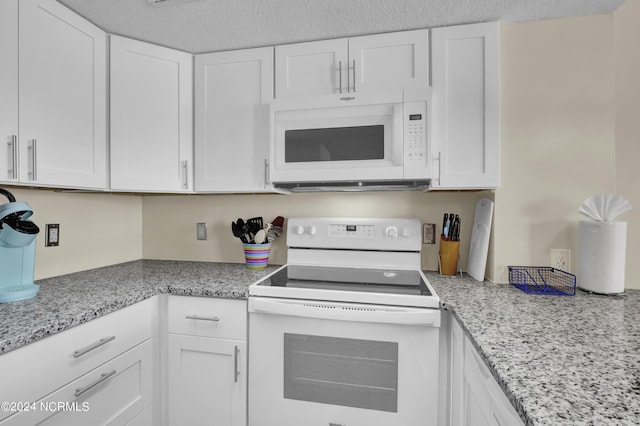 kitchen with white cabinets, white appliances, and light stone counters