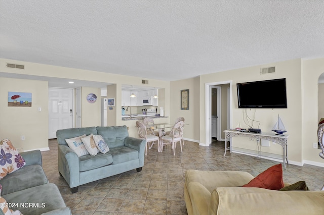 living room with a textured ceiling and sink