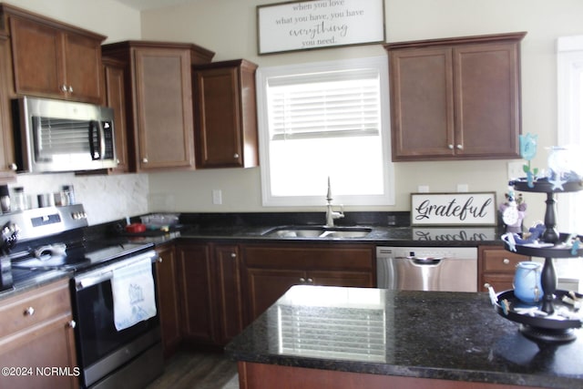 kitchen featuring sink, appliances with stainless steel finishes, and dark stone counters