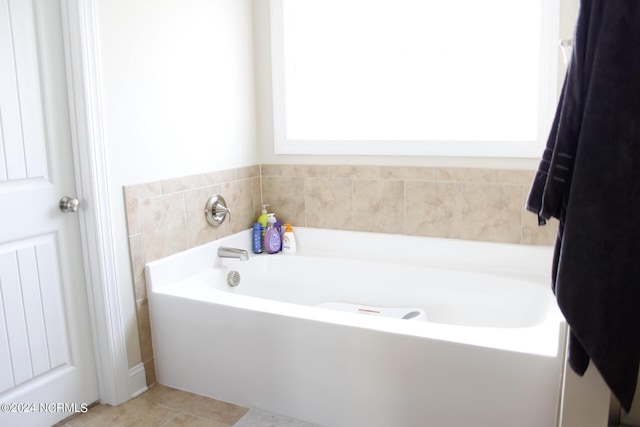 bathroom with a garden tub and tile patterned floors