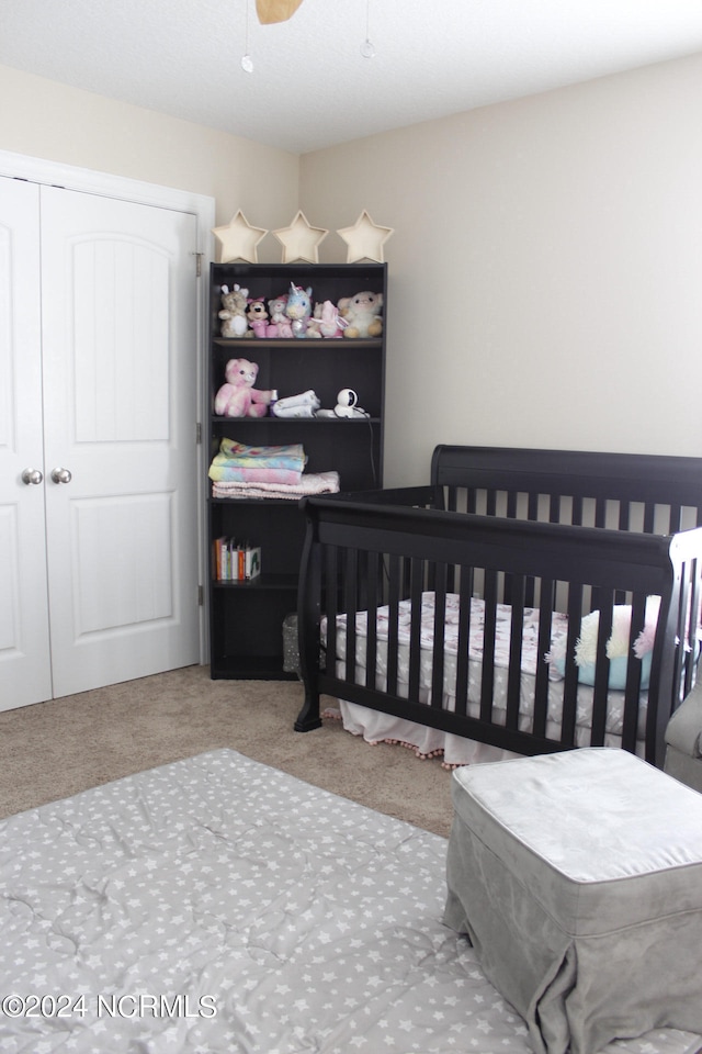 carpeted bedroom featuring ceiling fan and a closet