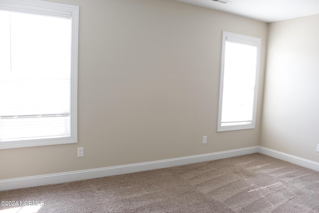 empty room with baseboards and light colored carpet