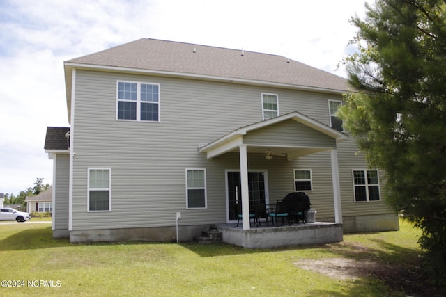 back of property with a lawn, ceiling fan, and a patio