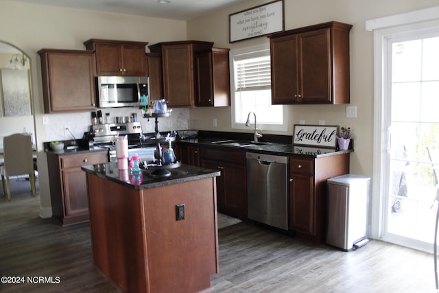 kitchen with sink, a kitchen island, light hardwood / wood-style flooring, and appliances with stainless steel finishes