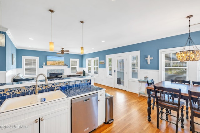 kitchen with dishwasher, sink, decorative light fixtures, white cabinets, and ceiling fan with notable chandelier