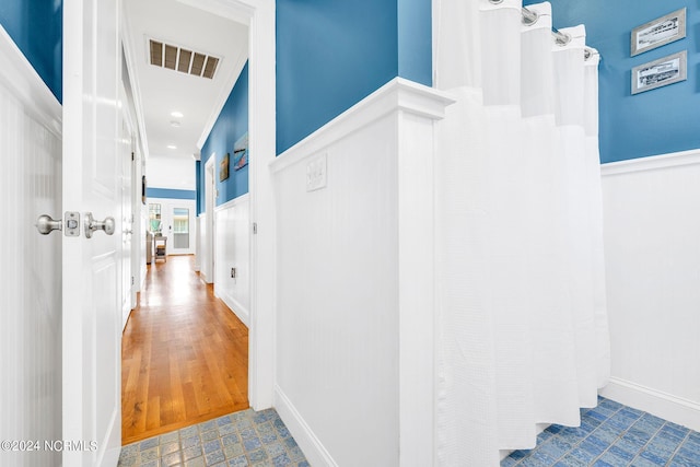 hallway with crown molding and hardwood / wood-style floors