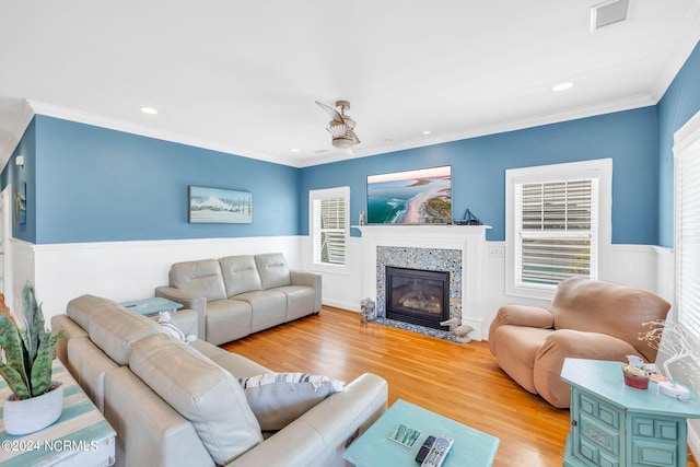 living room with a fireplace, light hardwood / wood-style floors, and ornamental molding