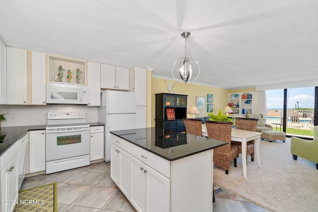 kitchen featuring pendant lighting, white appliances, tasteful backsplash, white cabinets, and a chandelier