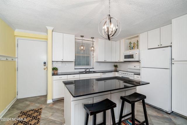 kitchen with sink, white appliances, a center island, white cabinets, and decorative light fixtures