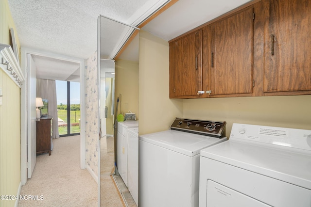 laundry area with washer and clothes dryer, light carpet, and a textured ceiling