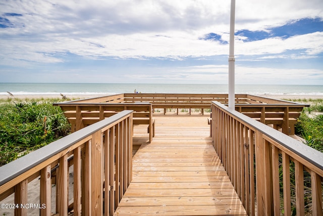 view of property's community featuring a water view and a beach view