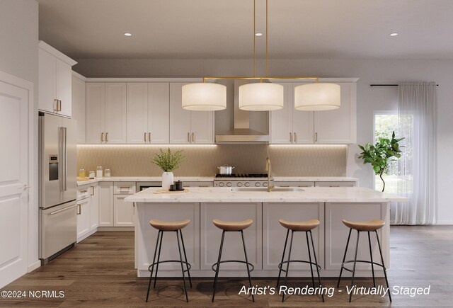 kitchen featuring appliances with stainless steel finishes, a kitchen island with sink, hardwood / wood-style floors, decorative light fixtures, and tasteful backsplash