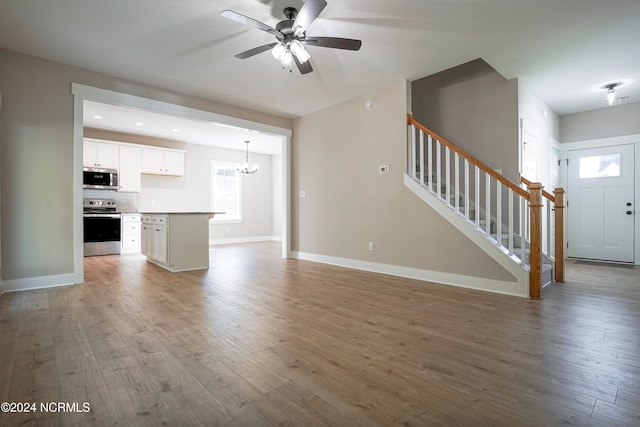 unfurnished living room with light hardwood / wood-style floors and ceiling fan with notable chandelier