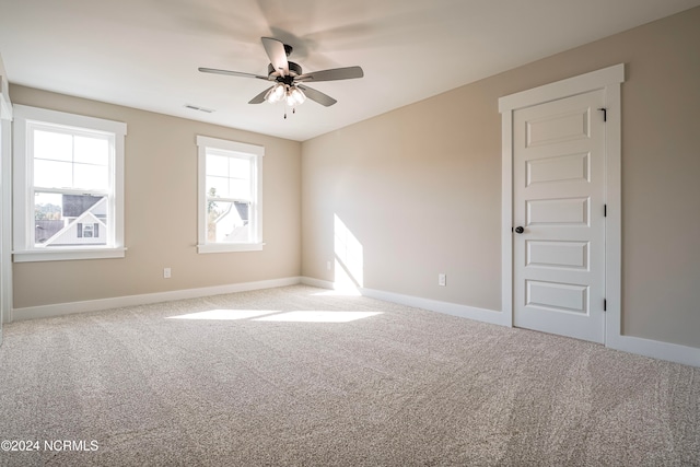 carpeted spare room with ceiling fan