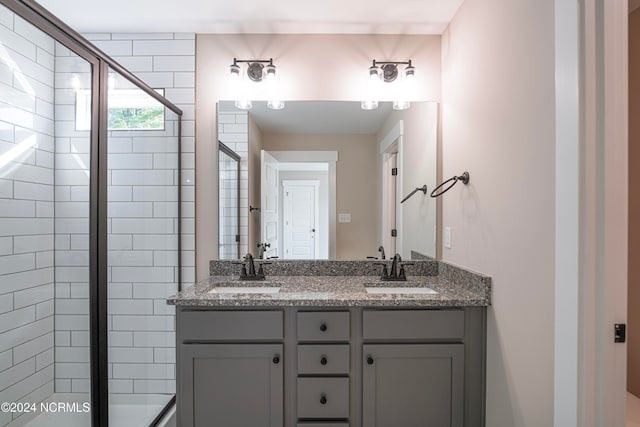 bathroom with vanity and a shower with door