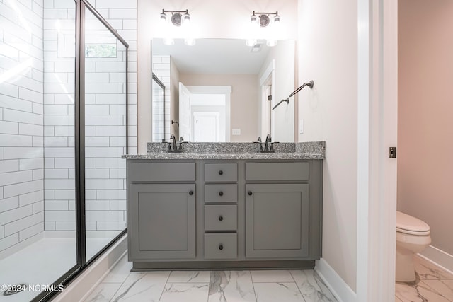 bathroom featuring a shower with door, vanity, and toilet