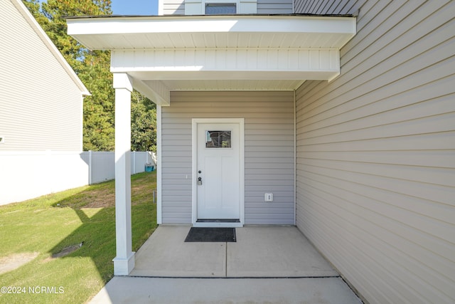 property entrance with a lawn