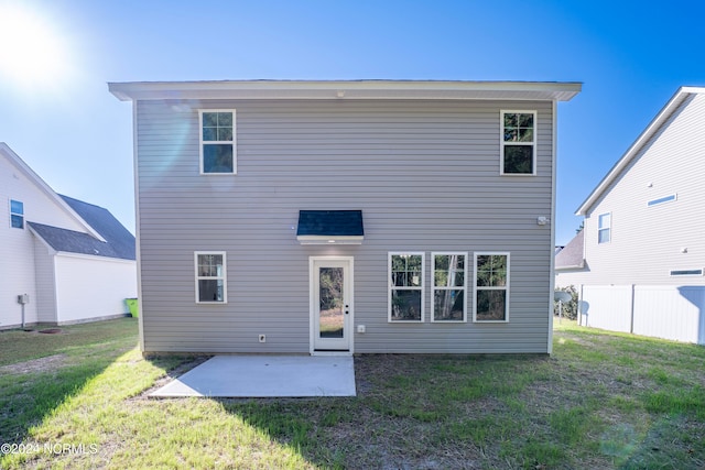 back of property featuring a patio area and a lawn