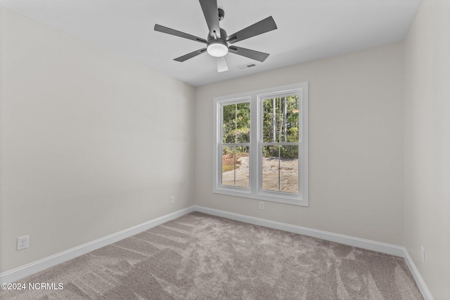 empty room featuring ceiling fan and light carpet