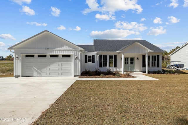 view of front facade featuring a garage, a front yard, and a porch