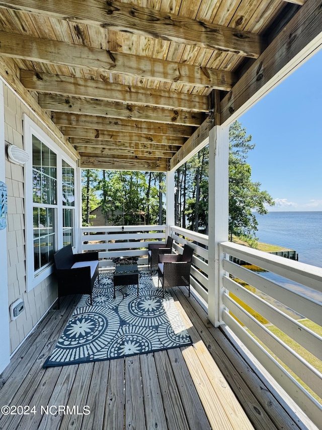 wooden terrace with outdoor lounge area and a water view