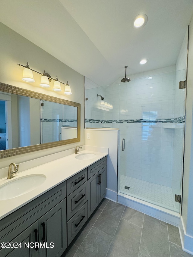 bathroom featuring tile patterned flooring, vanity, and a shower with shower door