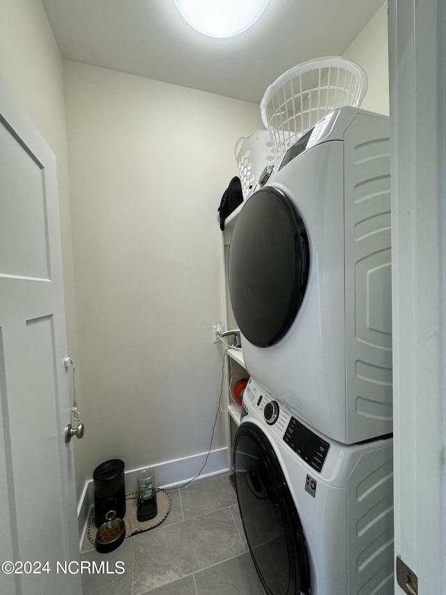 laundry area featuring stacked washer and dryer and light tile patterned floors