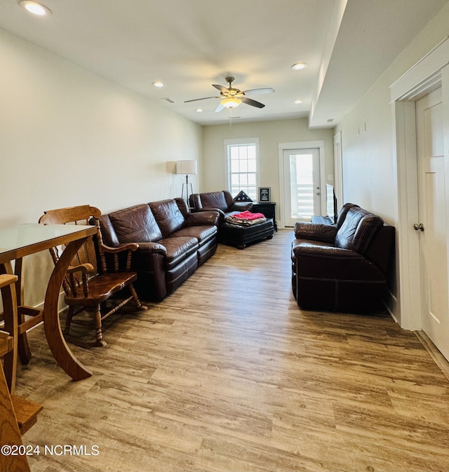 living room with light hardwood / wood-style flooring and ceiling fan