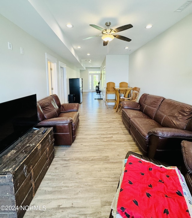 living room featuring ceiling fan and light hardwood / wood-style floors