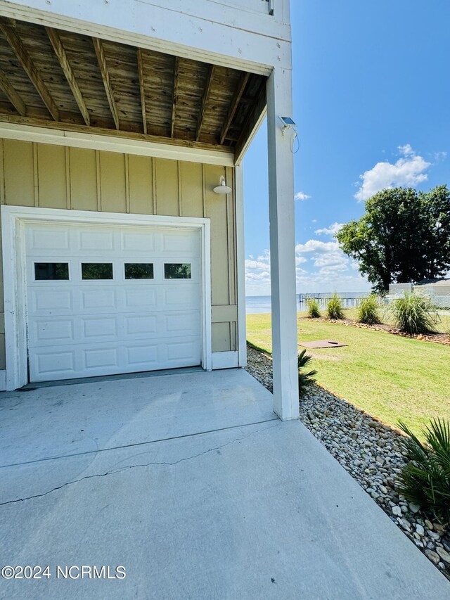 garage featuring a lawn and a water view