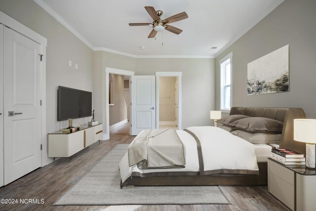 bedroom featuring a closet, ensuite bathroom, ceiling fan, ornamental molding, and dark wood-type flooring