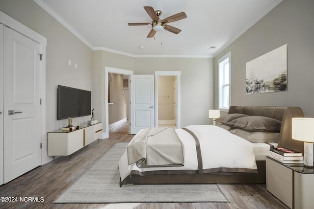 bedroom with ceiling fan, ornamental molding, connected bathroom, and hardwood / wood-style floors