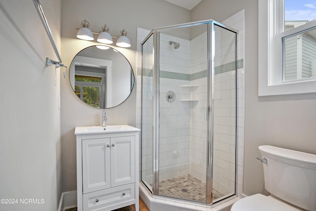 bathroom featuring a shower with shower door, oversized vanity, and toilet