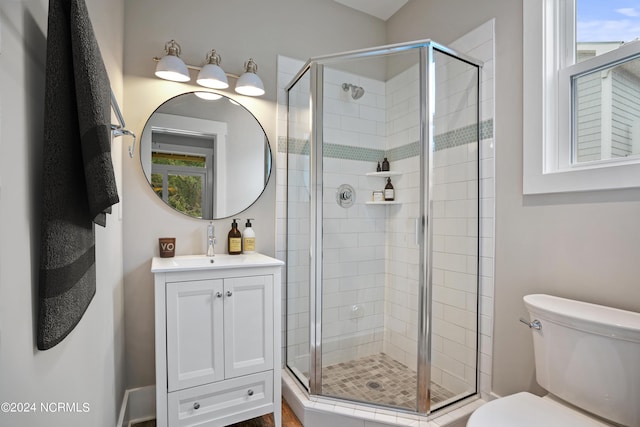 bathroom with a shower with shower door, toilet, and large vanity