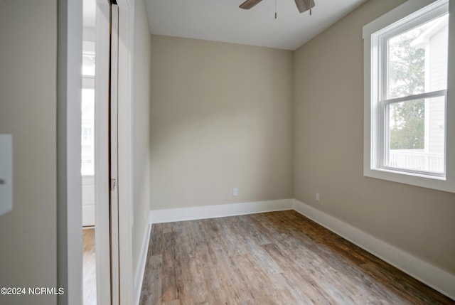 unfurnished room featuring plenty of natural light, ceiling fan, and wood-type flooring