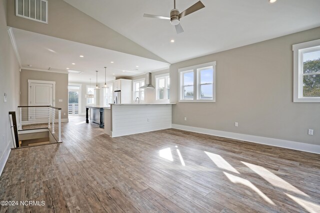 unfurnished living room with high vaulted ceiling, sink, wood-type flooring, and ceiling fan