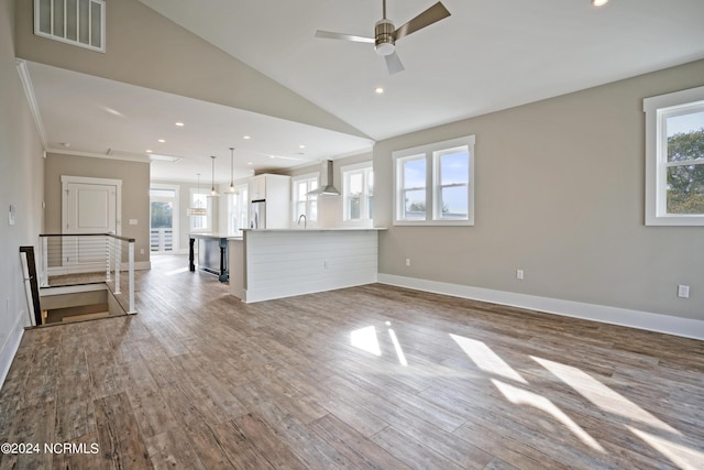 unfurnished living room featuring light hardwood / wood-style flooring, lofted ceiling, ceiling fan, crown molding, and sink