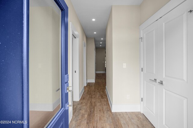 hallway with light hardwood / wood-style floors