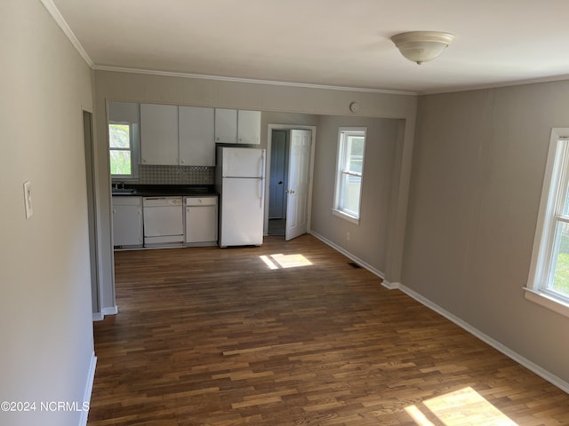 kitchen with dark countertops, white appliances, and dark wood finished floors